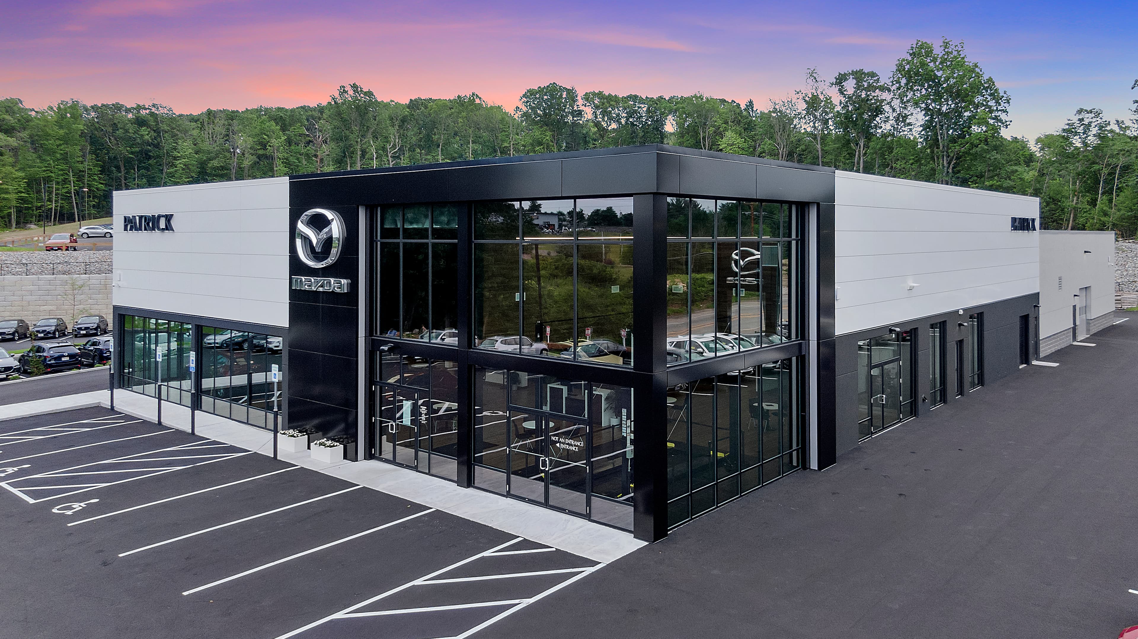 Patrick Mazda dealership exterior at sunset in Auburn, Massachusetts